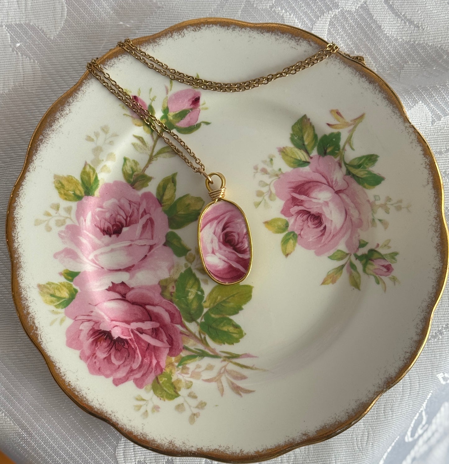 Necklace with a pendant on a decorative plate with floral design