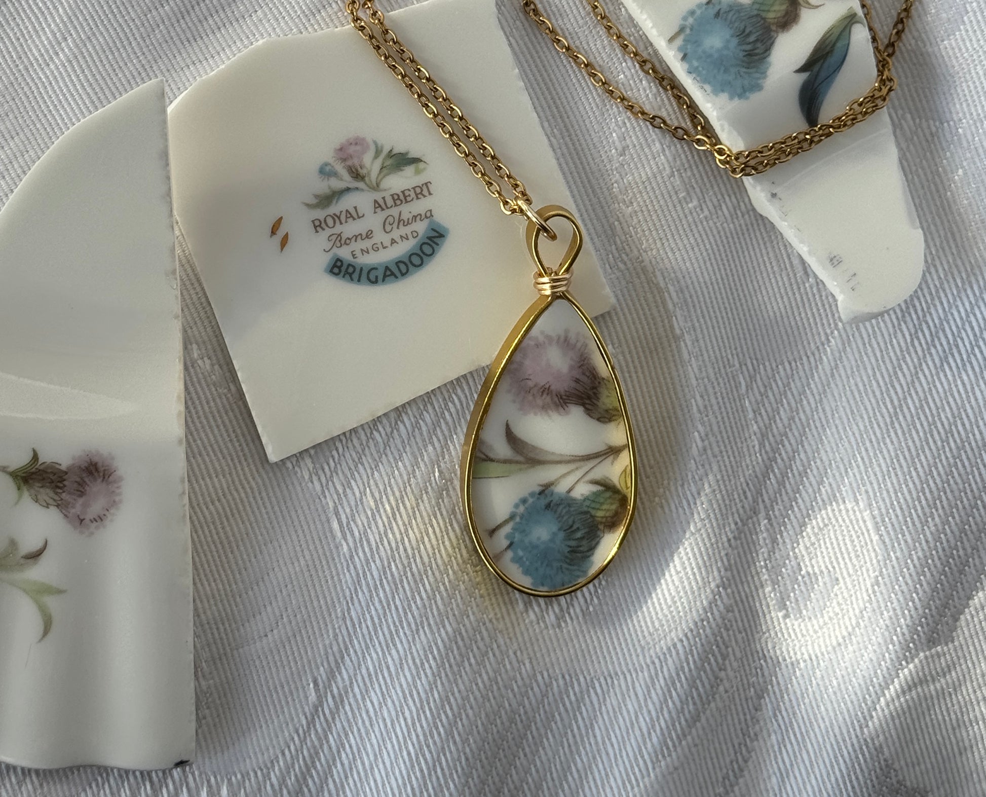 Teardrop-shaped pendant with floral design on a white background