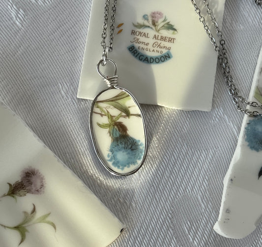 Necklace with a pendant featuring floral design on a Royal Albert tag.