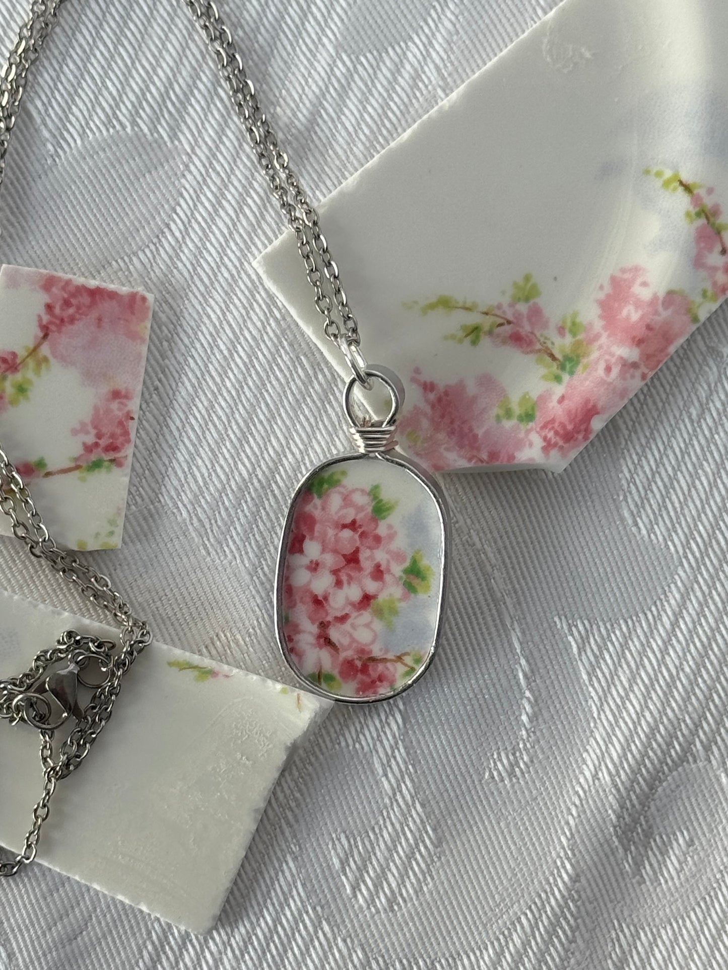 Necklace with a floral pendant on a floral-patterned card