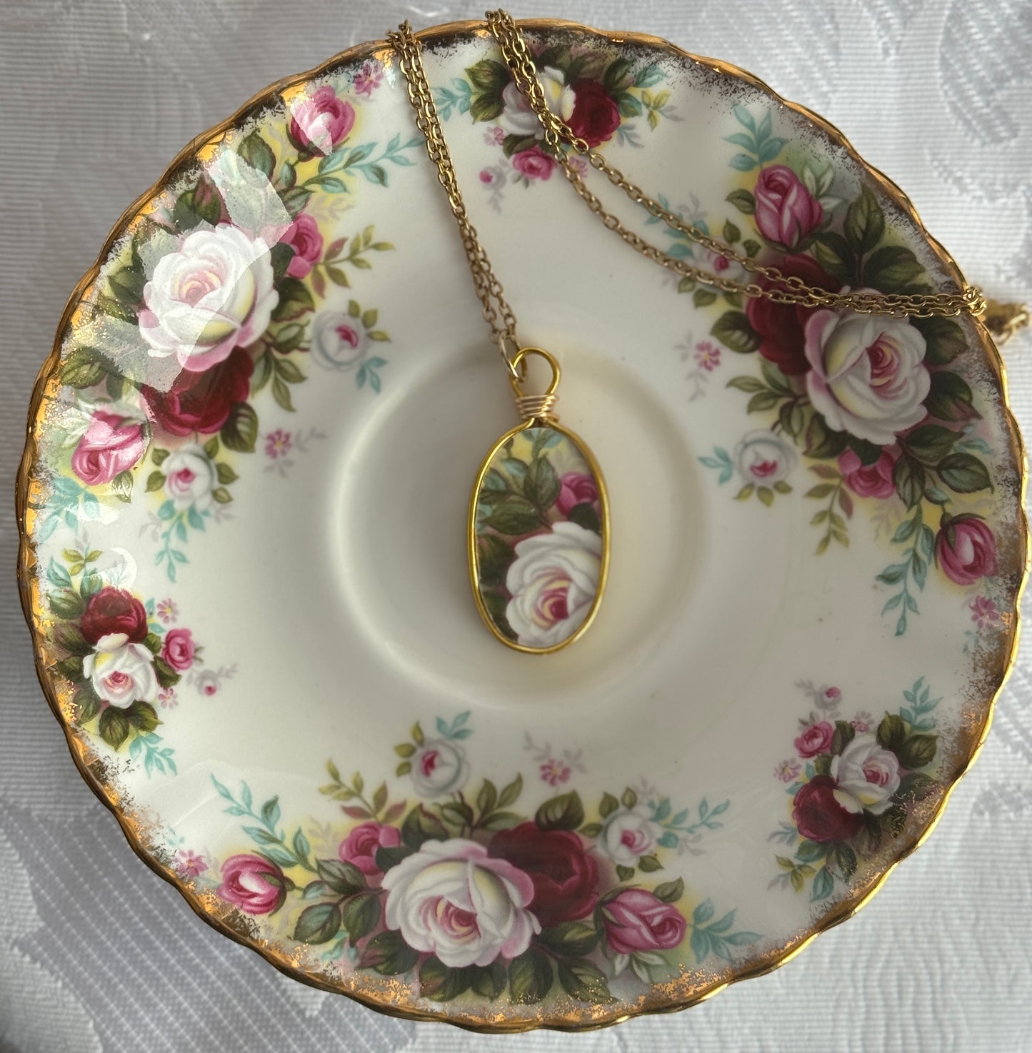 Necklace with a pendant on a floral teacup