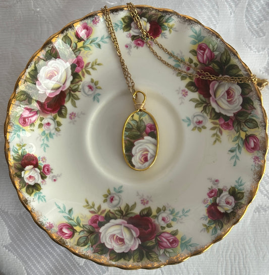 Necklace with a pendant on a floral teacup