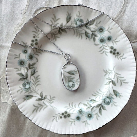 Necklace with a pendant on a floral-patterned plate