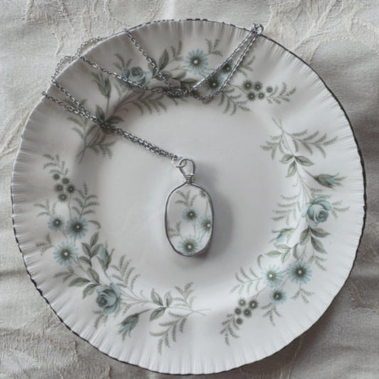Necklace with pendant on a floral-patterned plate
