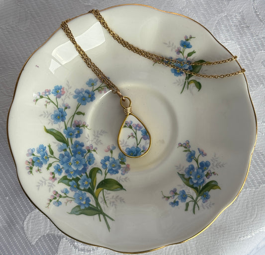 Necklace with a floral pendant on a decorative plate with floral patterns