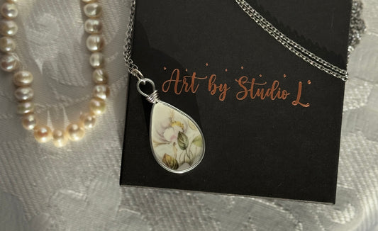 Necklace with a teardrop-shaped pendant on a card labeled 'Art by Studio L'.