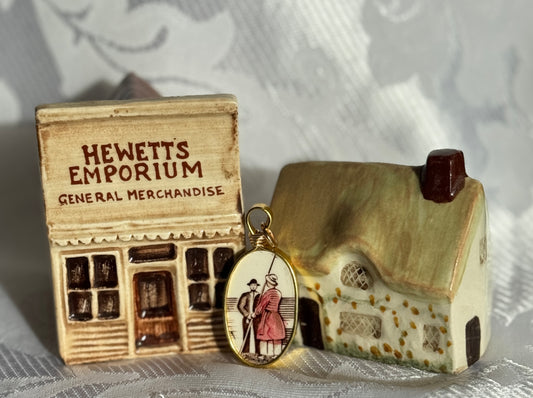 Miniature store model labeled 'Hewett's Emporium' with a pendant featuring a couple and a house.