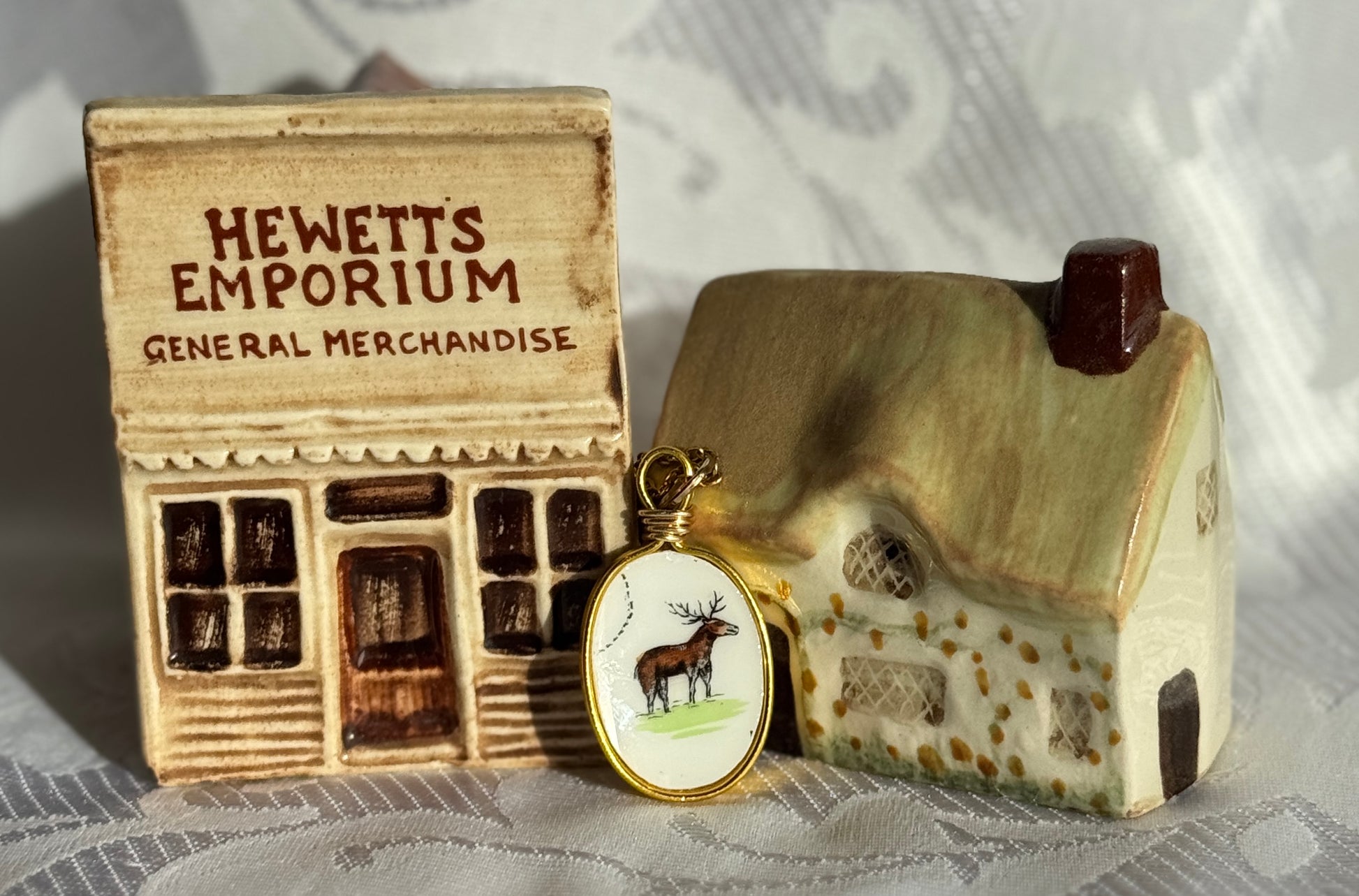 Small model of a store named 'Hewett's Emporium' with a house-shaped object featuring a moose emblem.