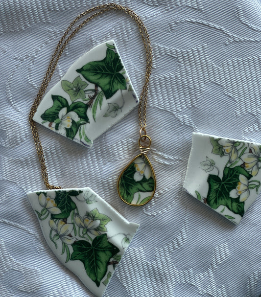 Necklace with floral pendant and matching pieces on a textured fabric background