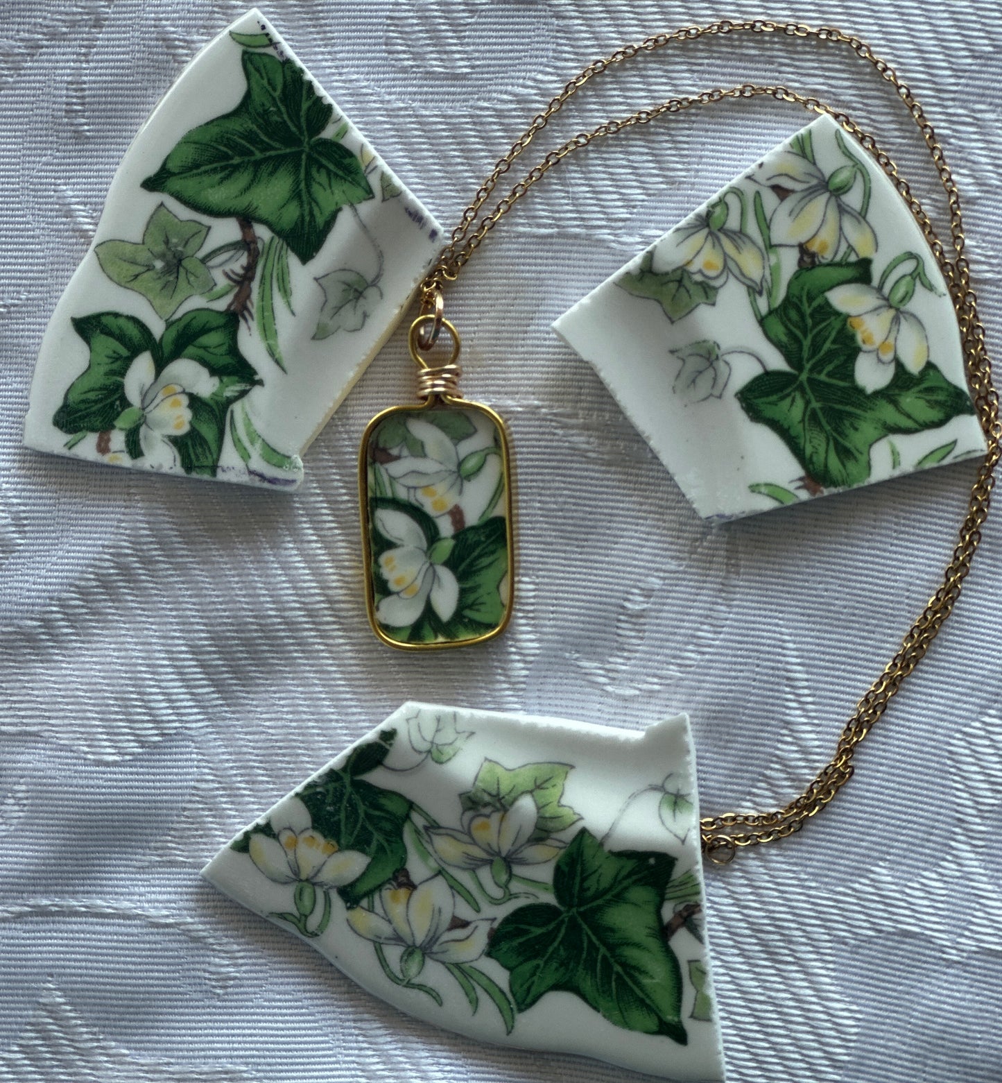 Necklace with pendant featuring floral design on a textured surface