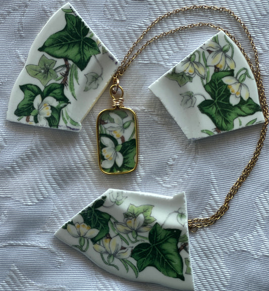 Necklace with pendant featuring floral design on a textured surface