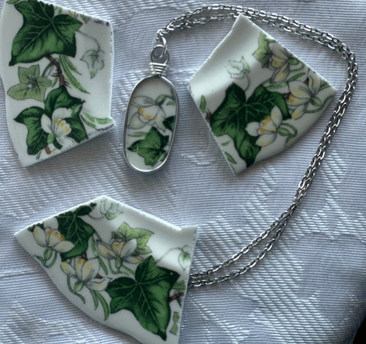 Jewelry set with pendant and chain on a floral-patterned surface