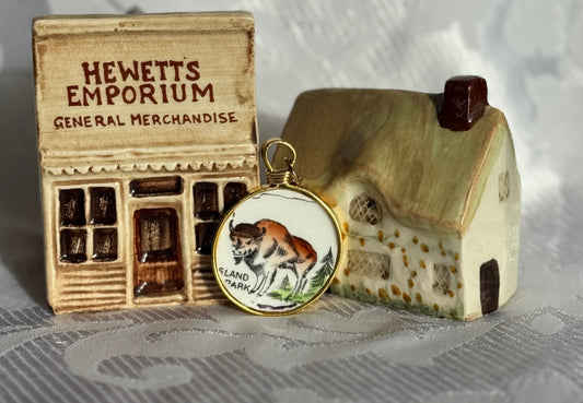 Small model of a general merchandise store with a house and a pendant featuring a Buffalo illustration.
