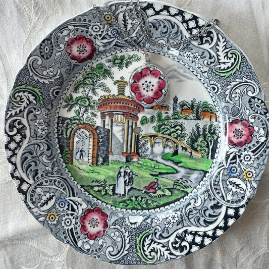 Decorative plate with intricate patterns and a scenic design on a textured fabric background