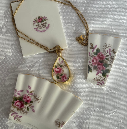 Necklace with floral pendant on a matching card and ribbon on a textured white background