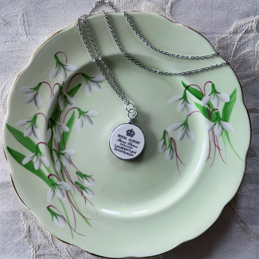 Necklace with a pendant on a decorative plate with floral design