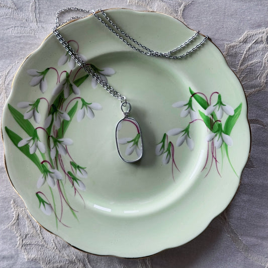 Necklace with a pendant on a decorative plate with floral design