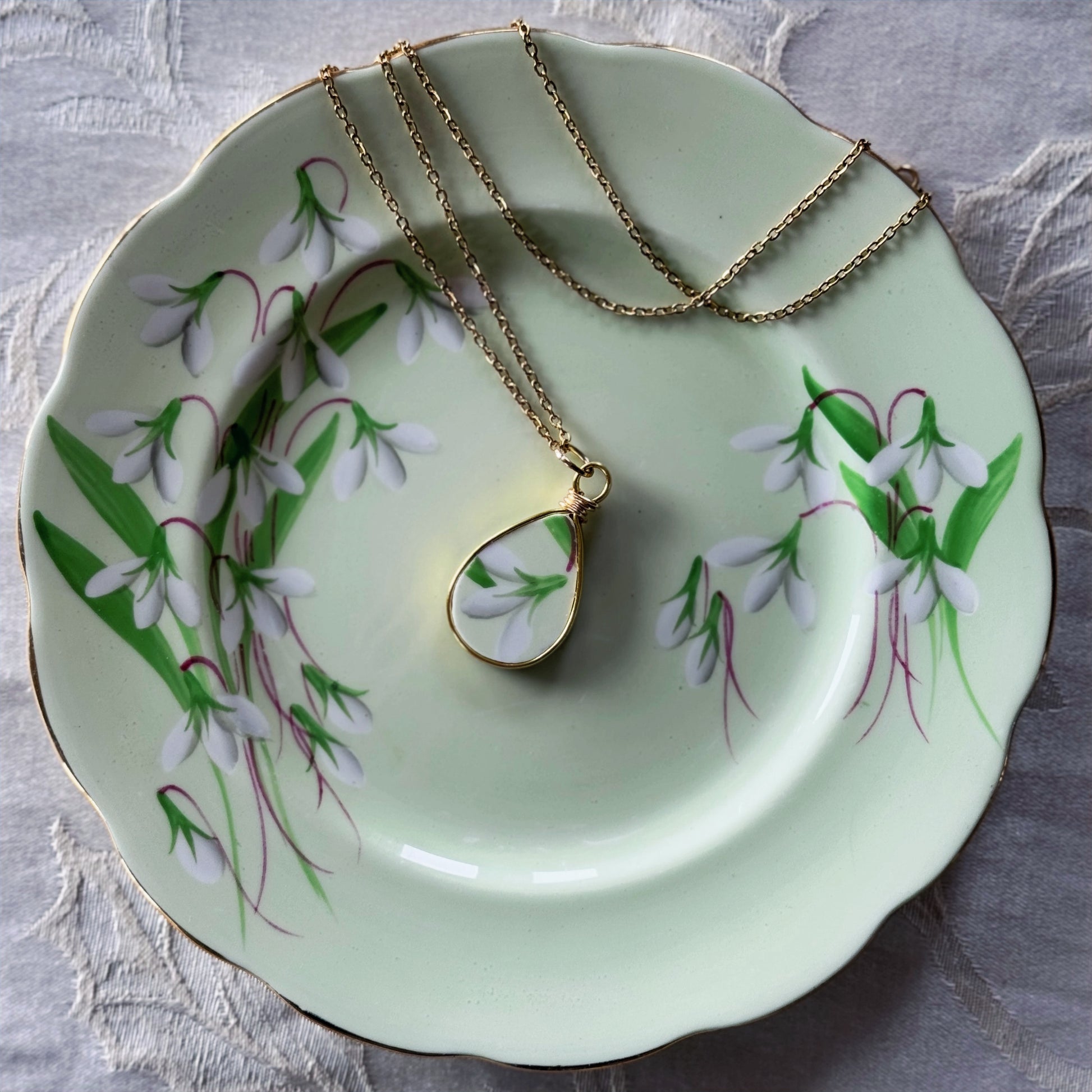 Necklace with a pendant on a decorative plate with floral design