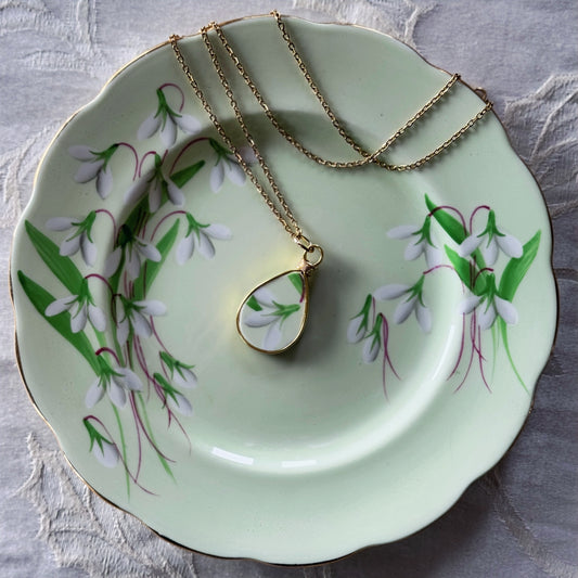 Necklace with a pendant on a decorative plate with floral design