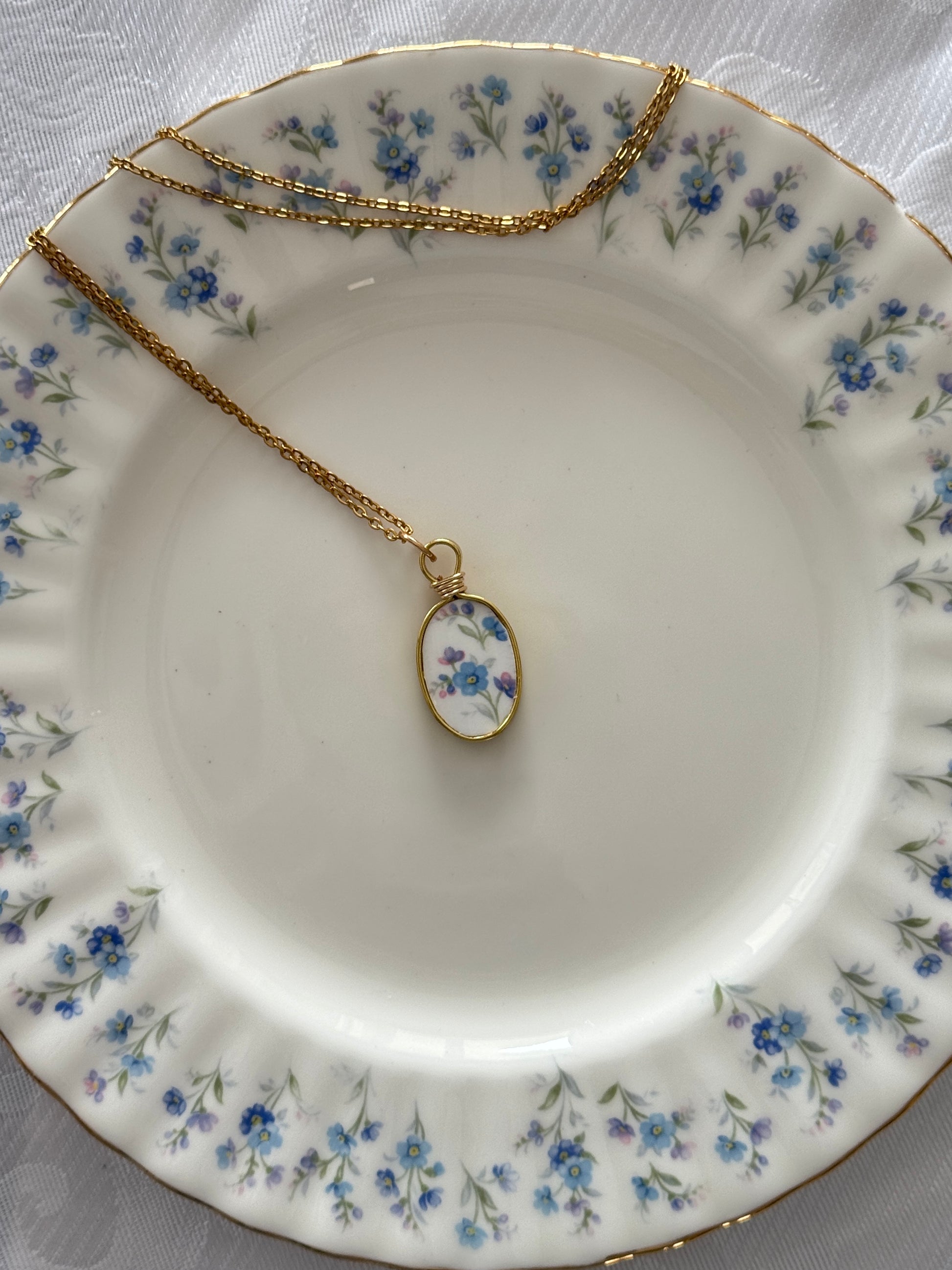 Necklace with a floral pendant on a decorative plate