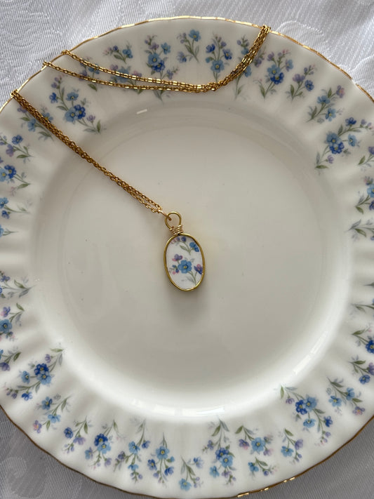 Necklace with a floral pendant on a decorative plate
