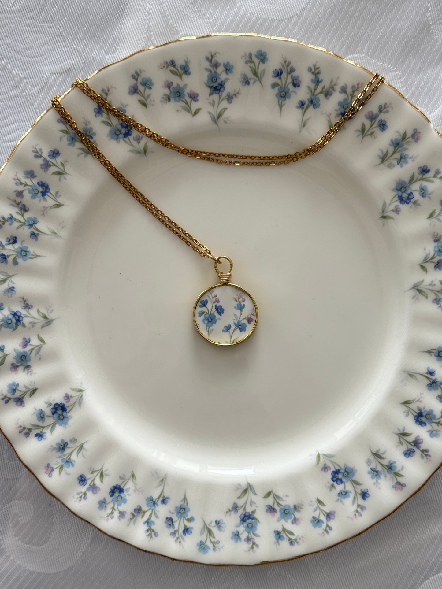 Necklace with a floral pendant on a decorative plate with floral patterns