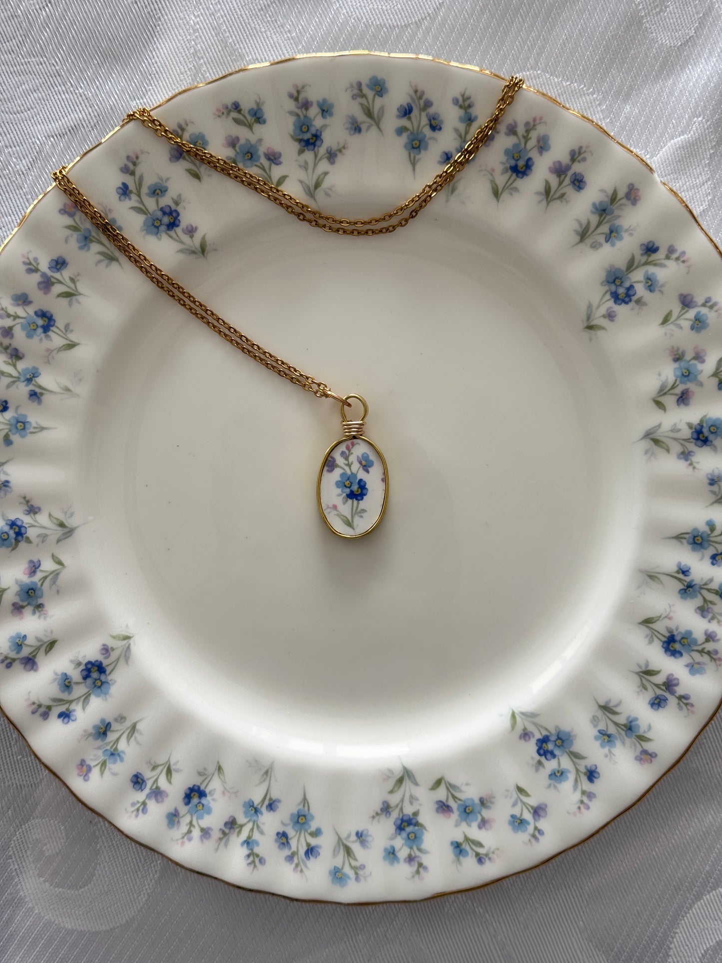 Necklace with an oval pendant on a floral-patterned plate