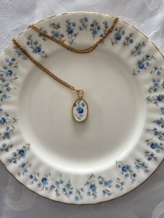 Necklace with an oval pendant on a floral-patterned plate