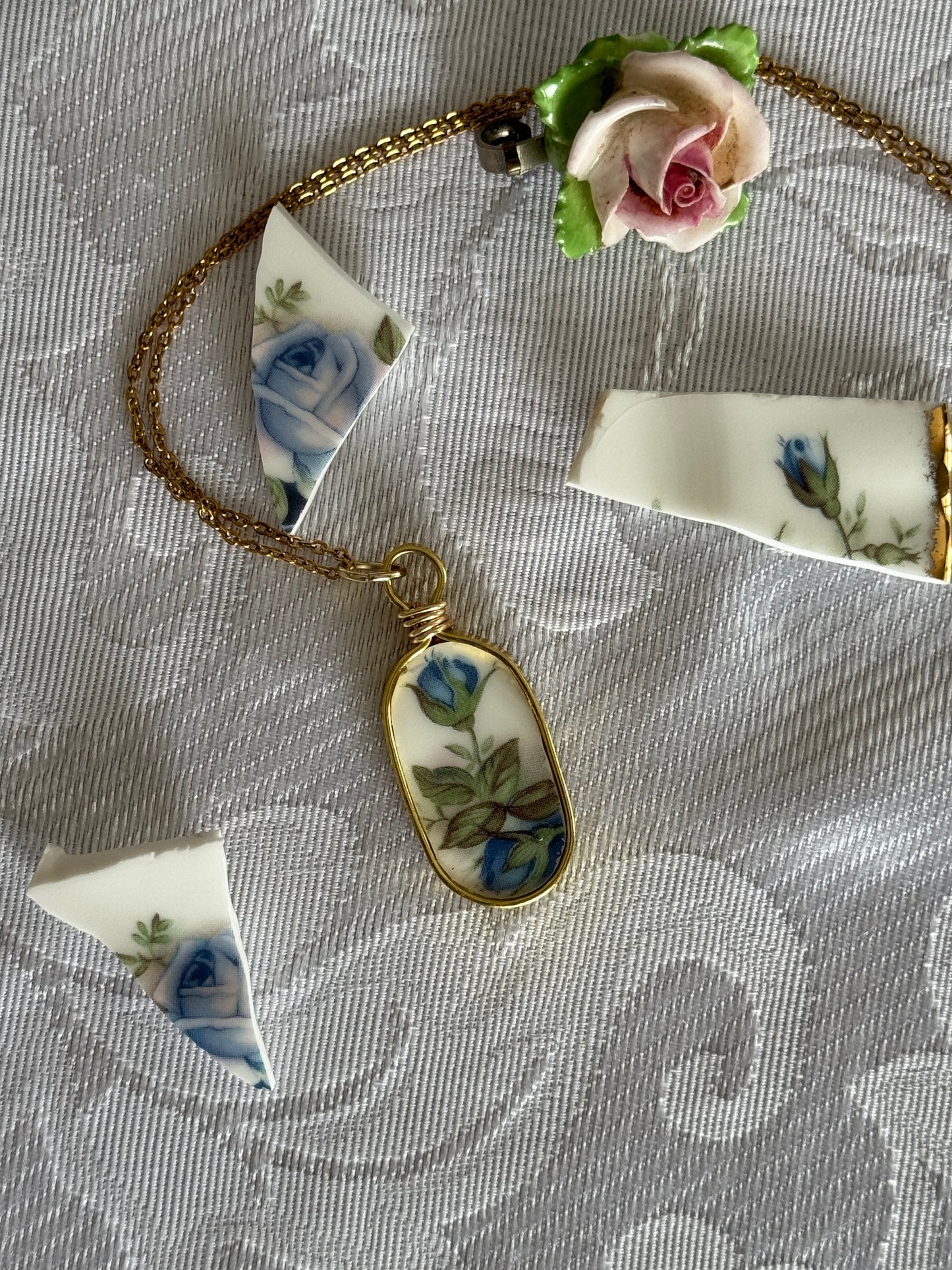 Necklace with floral pendant on a textured fabric background