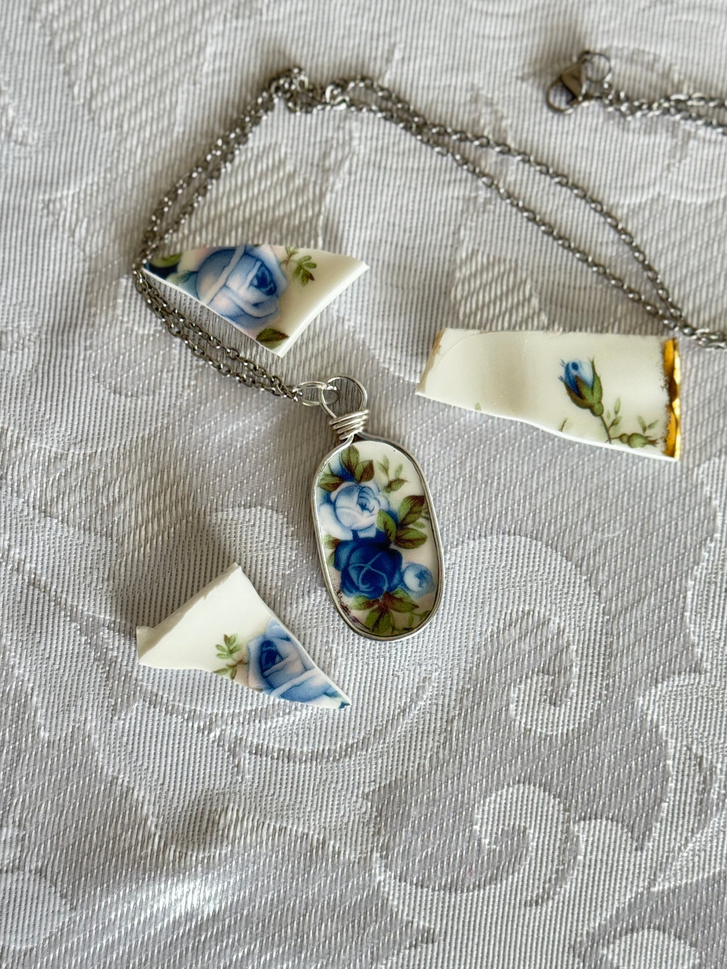 Necklace with a floral pendant on a textured fabric background