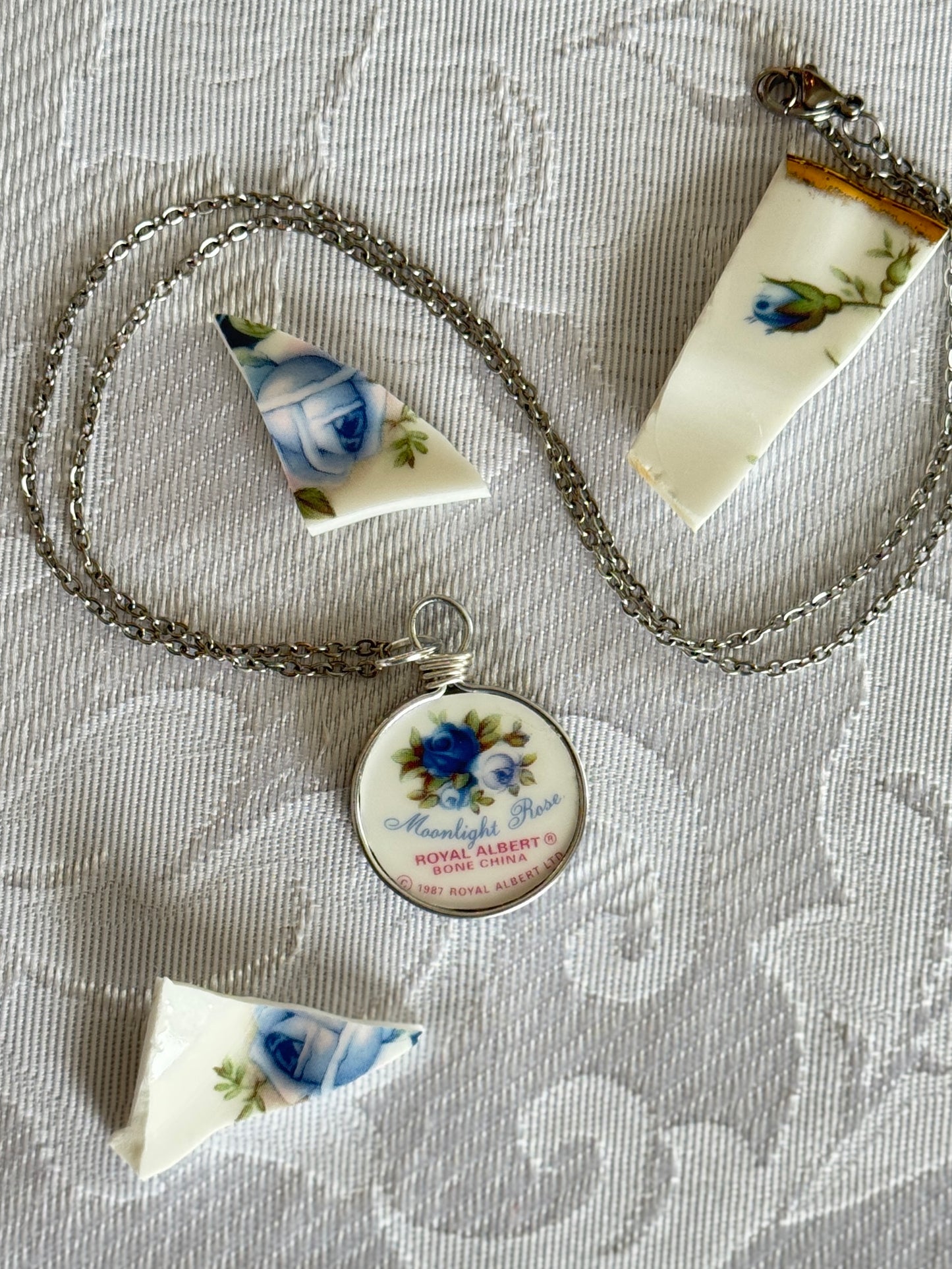 Necklace with a decorative pendant on a textured fabric background