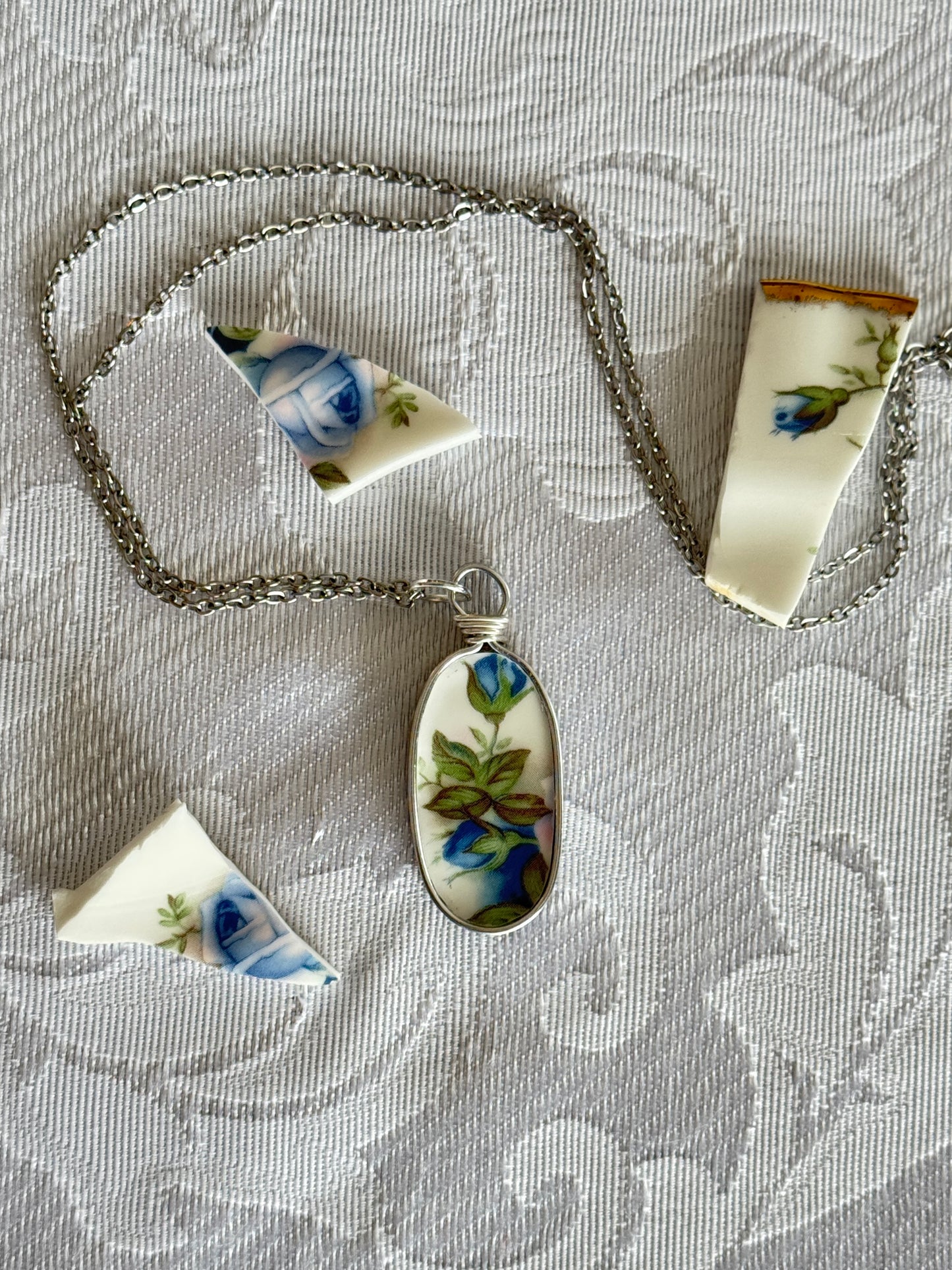 Necklace with a floral pendant on a textured surface