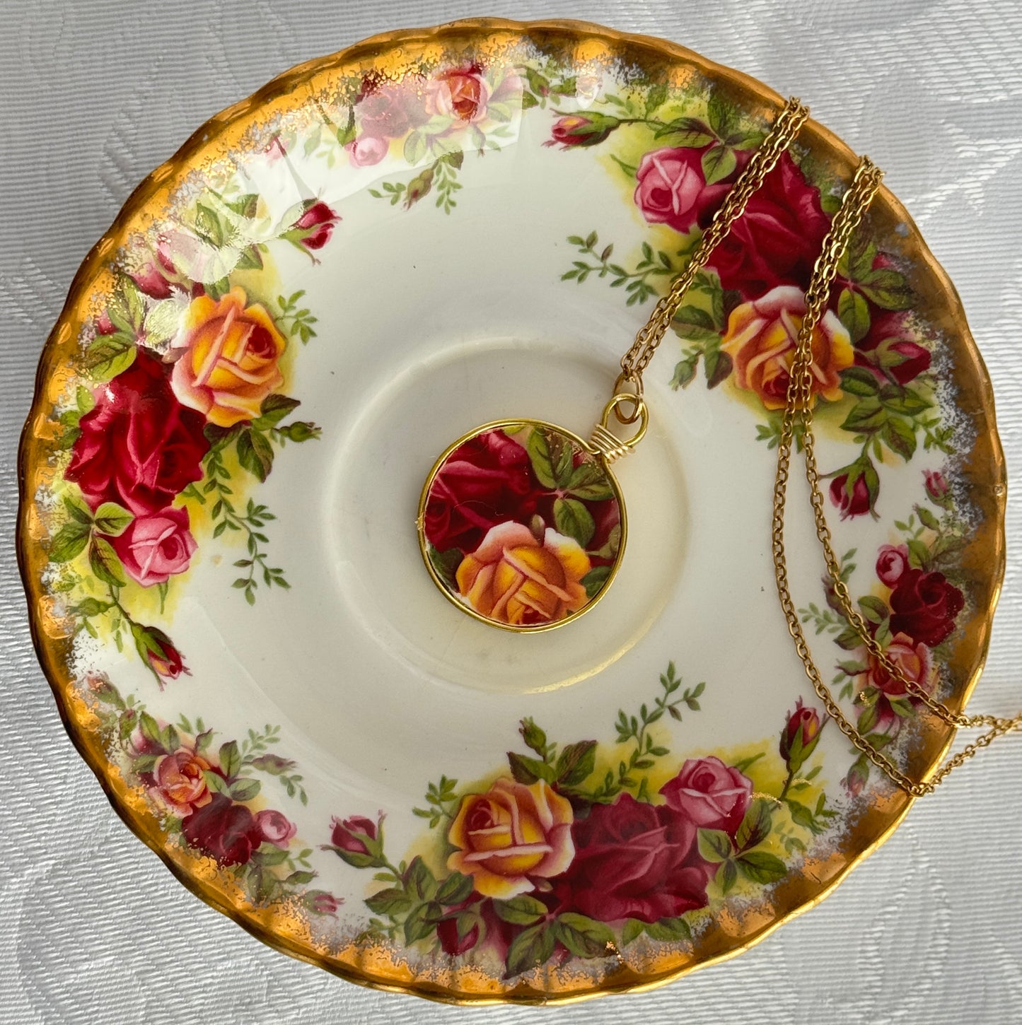 Necklace with pendant on a floral teacup