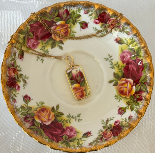 Necklace with a floral pendant on a decorative plate with rose pattern
