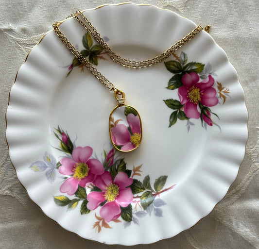 Necklace with a floral pendant on a decorative plate with floral patterns