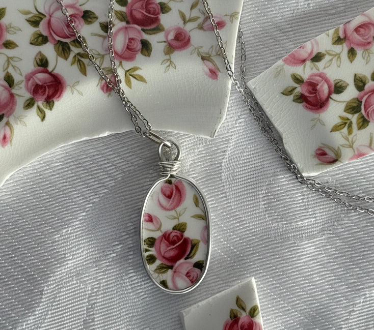 Necklace with a floral pendant on a floral-patterned fabric background