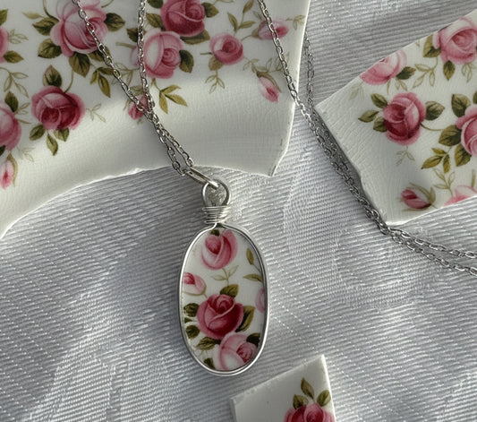 Necklace with a floral pendant on a floral-patterned fabric background