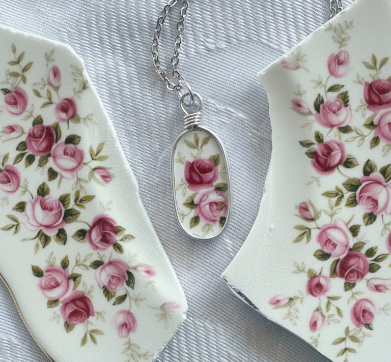 Necklace with a floral pendant on a floral-patterned surface