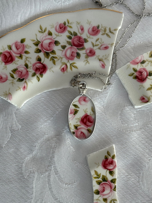 Decorative necklace with floral pendant on a textured surface