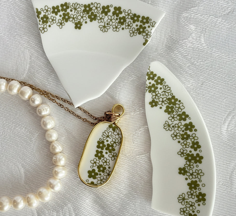 Pearl necklace with a floral pendant on a textured surface