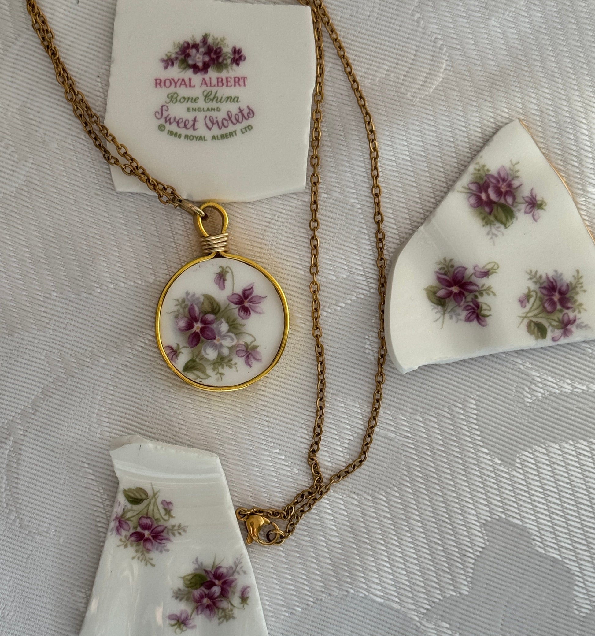 Necklace with floral pendant on a textured white fabric background