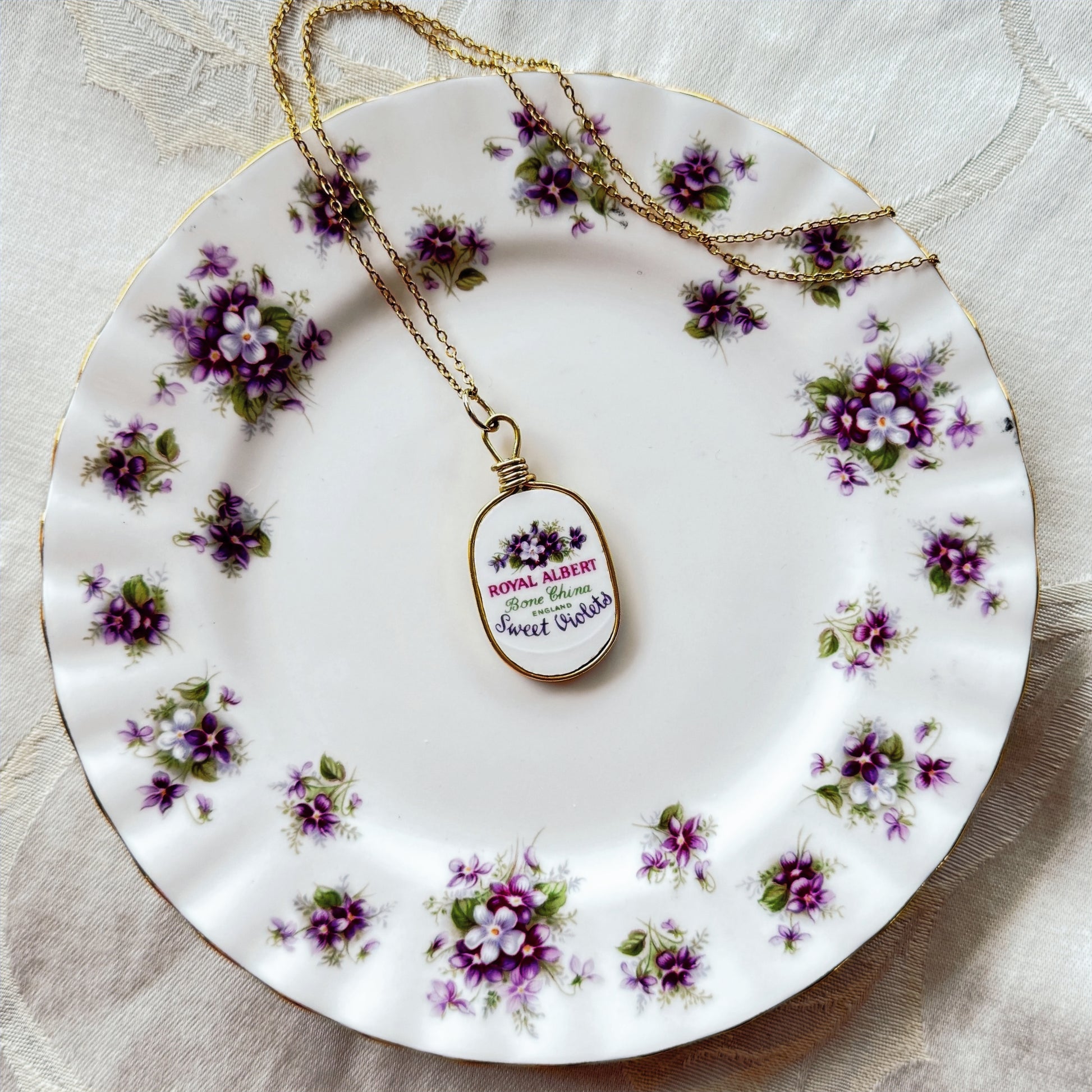 Necklace with a pendant on a decorative plate with floral patterns