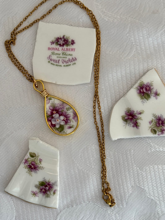 Vintage Royal Albert necklace with floral design on a textured surface