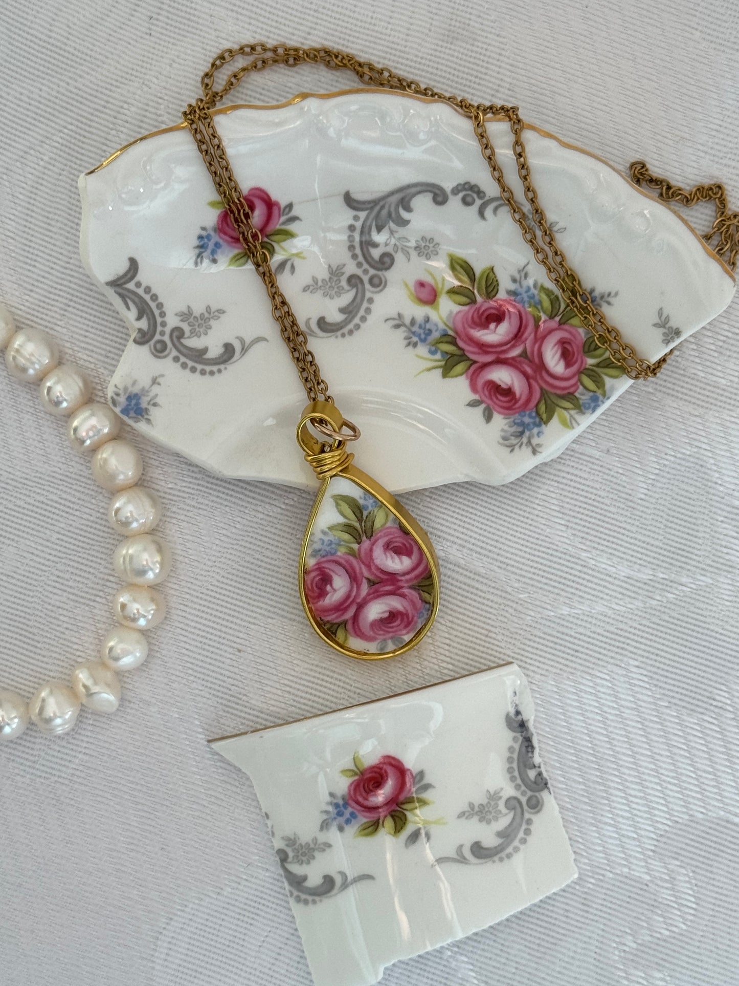 Necklace with a floral pendant on a decorative ceramic dish