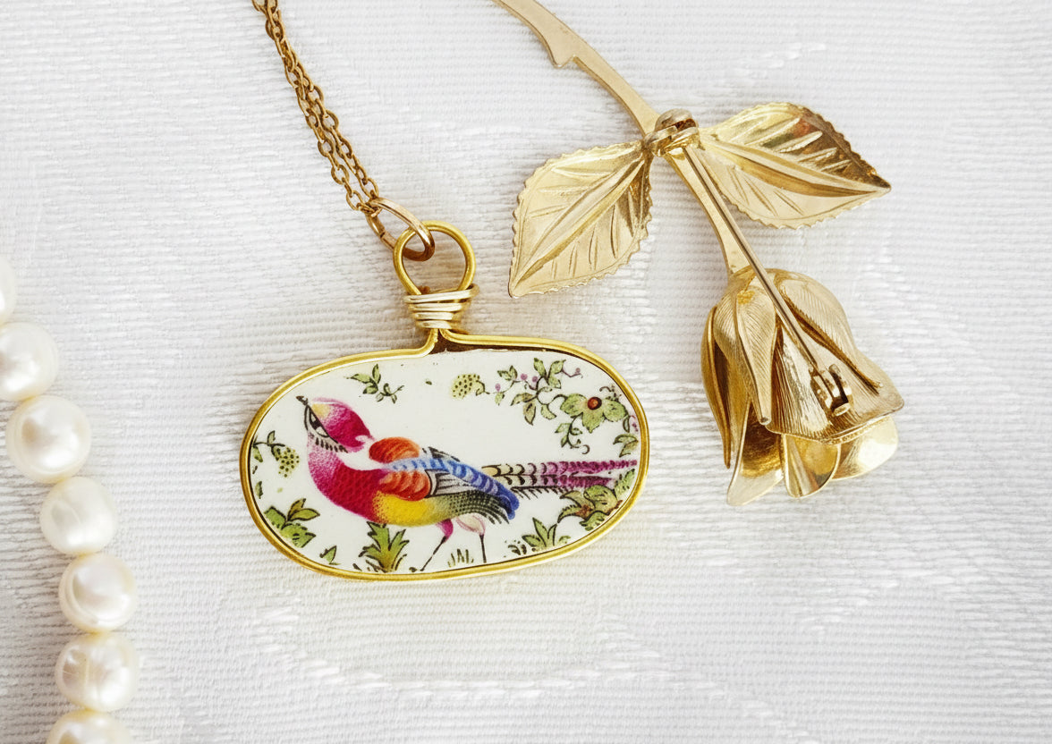 Necklace with a pendant featuring a colorful bird design on a white background