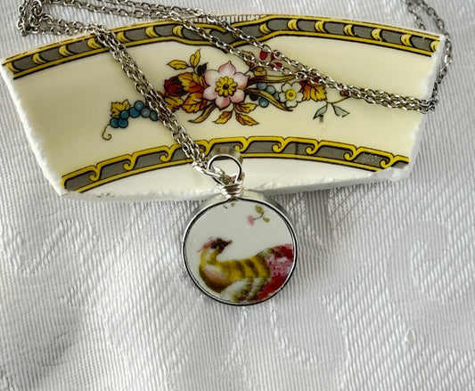 Necklace with a round pendant featuring a rooster design on a decorative plate background.