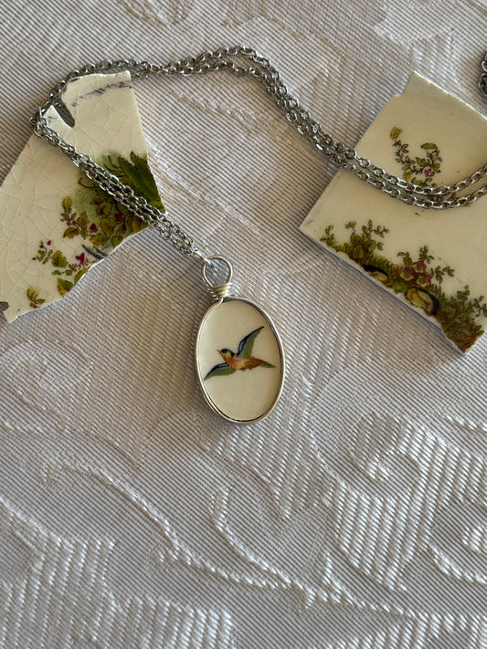 Necklace with a pendant featuring a bird design on a textured fabric background