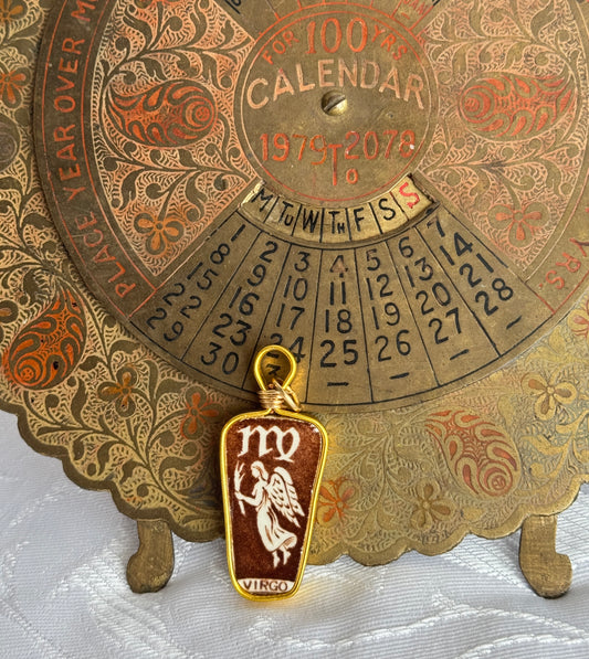 Decorative calendar with virgo zodiac pendant on a textured surface